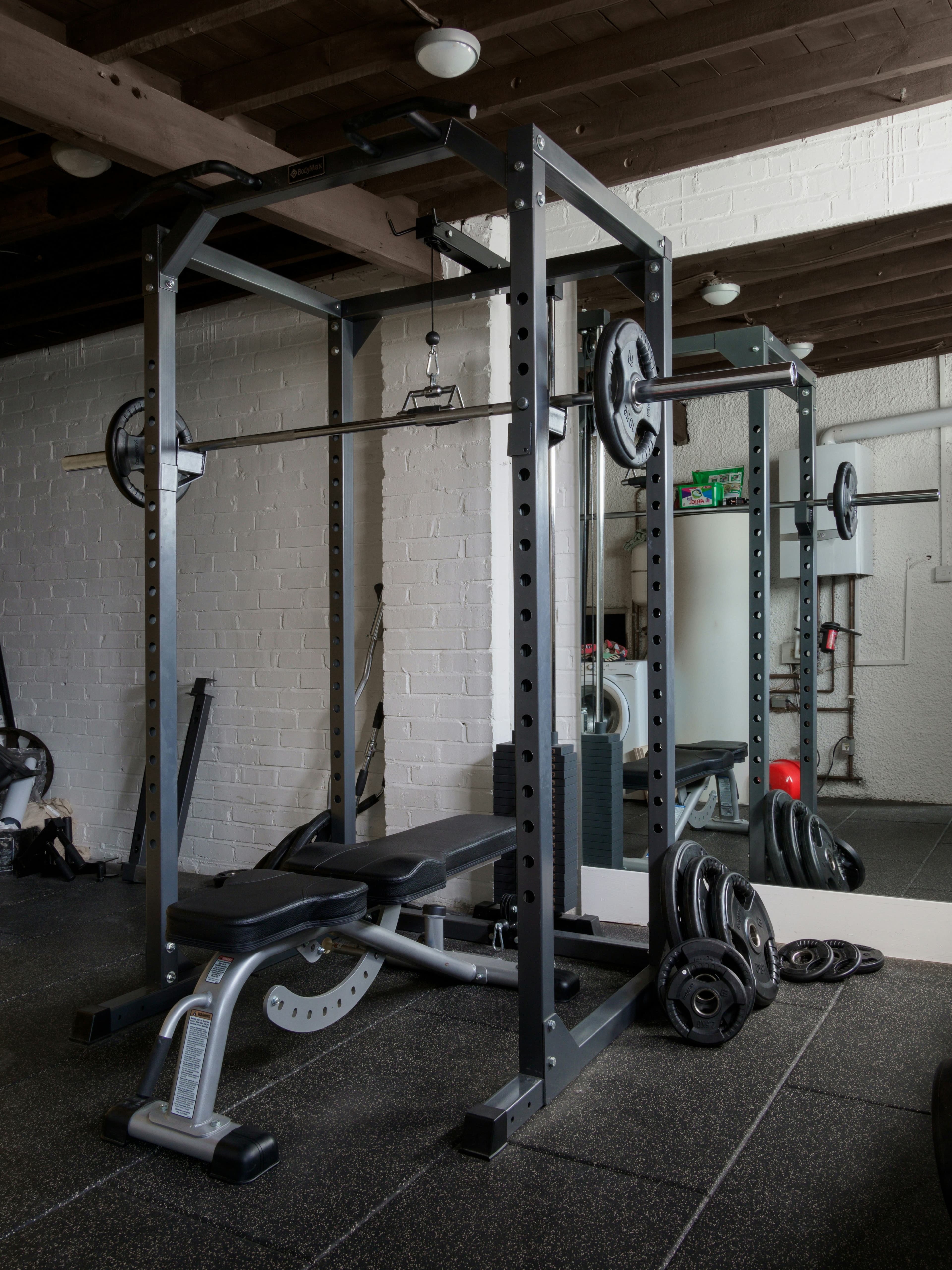 Home gym with a power rack, bench, and weights